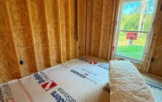 Johns Manville R19 wall batt insulation installed in a framed room with a window in a new construction America's Home Place home in Adairsville, GA.