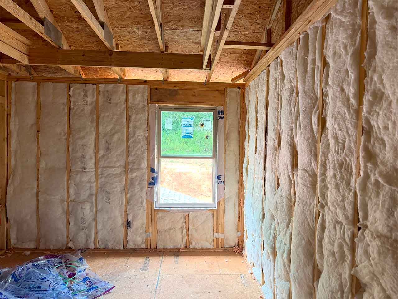 Wide view of fiberglass batt wall insulation installed in a framed DRB Homes new construction home in Stockbridge, GA by Foster Insulation.