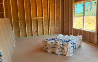 Bagged new home insulation staged in an open framed room at Kingston Park in Kingston, GA.