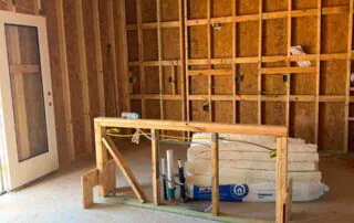 New home insulation staged near a doorway ahead of install at Kingston Park in Kingston, GA.
