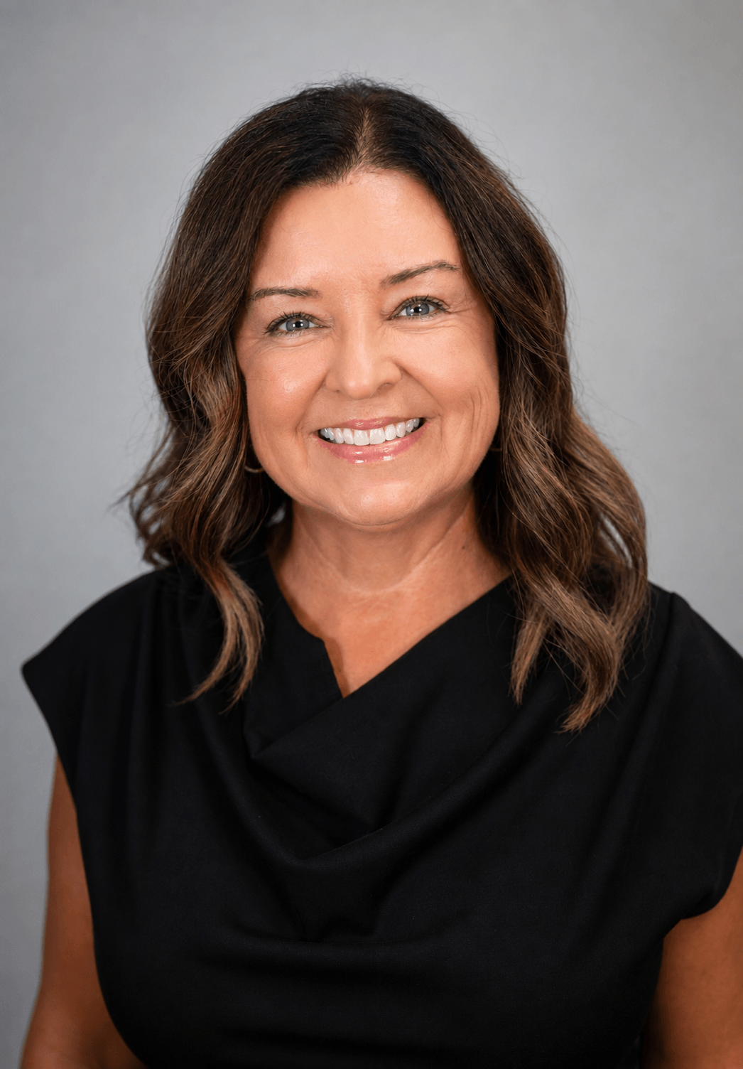 Angela Luck smiling, wearing a black top against a plain background, associated with Foster Insulation
