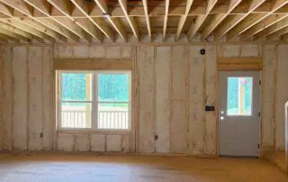Foster Insulation batt insulation installed in a living area wall with a window and exterior door in Blue Ridge, GA.