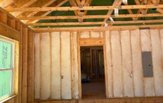 Foster Insulation batt insulation installed in wall studs beneath open roof trusses in Blue Ridge, GA.