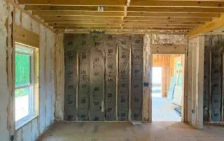 JM batt insulation installed in wall cavities near an interior doorway in Blue Ridge, GA.