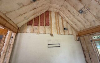 Foster Insulation fiberglass batt insulation installed in a vaulted ceiling and gable end above an existing interior wall during a residential remodel.
