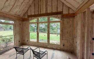 Foster Insulation fiberglass batt insulation installed in a vaulted ceiling and gable wall around arched windows during a residential remodel.