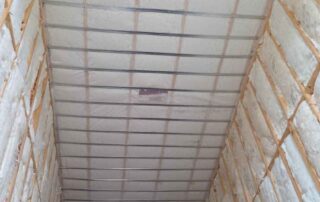 Fiberglass batt insulation installed in the walls and ceiling of a stairwell during a residential remodel.