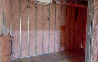 Fiberglass batt insulation installed in walls during a residential remodel.