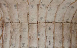 Close-up of fiberglass batt insulation in a vaulted ceiling during a residential remodel.